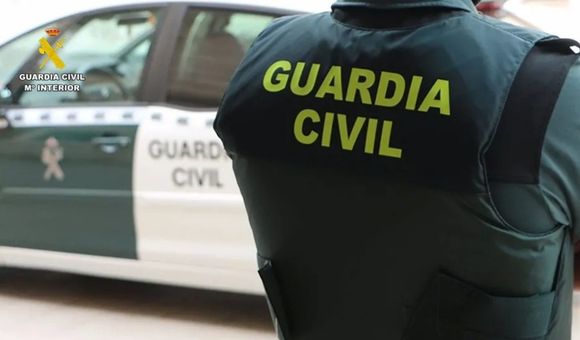 Un agente de la Guardia Civil junto a un vehículo oficial