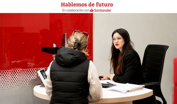 Una agente de Santander atiende a una clienta en una oficina.